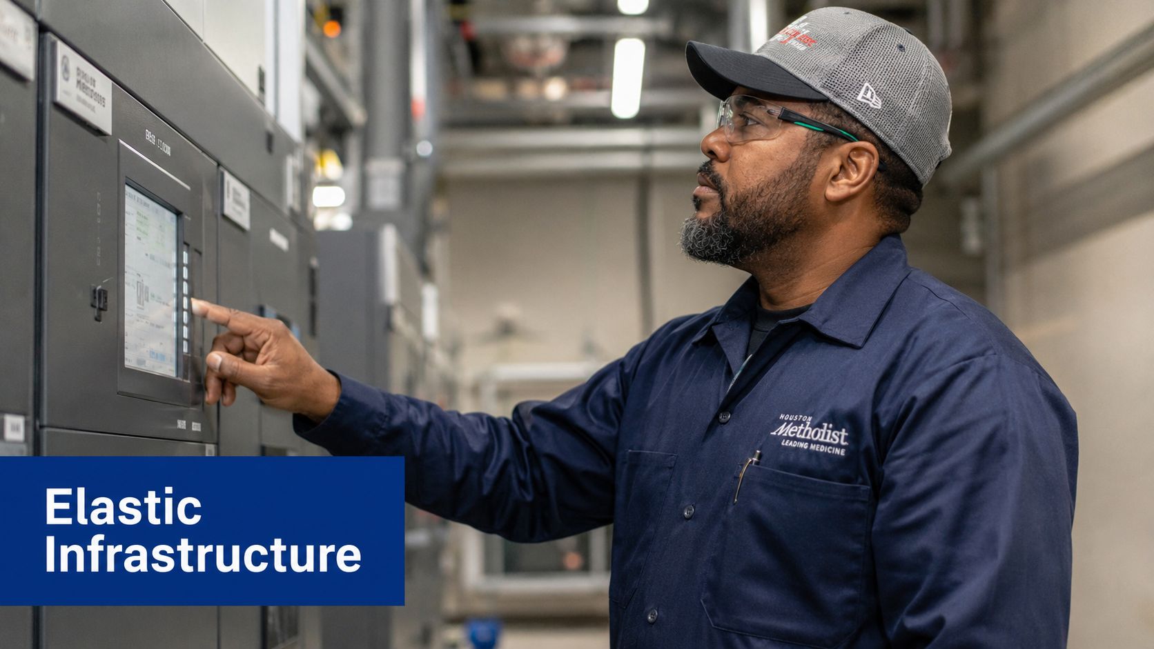A technician wearing a Houston Methodist uniform monitors a digital interface on an industrial infrastructure control panel.