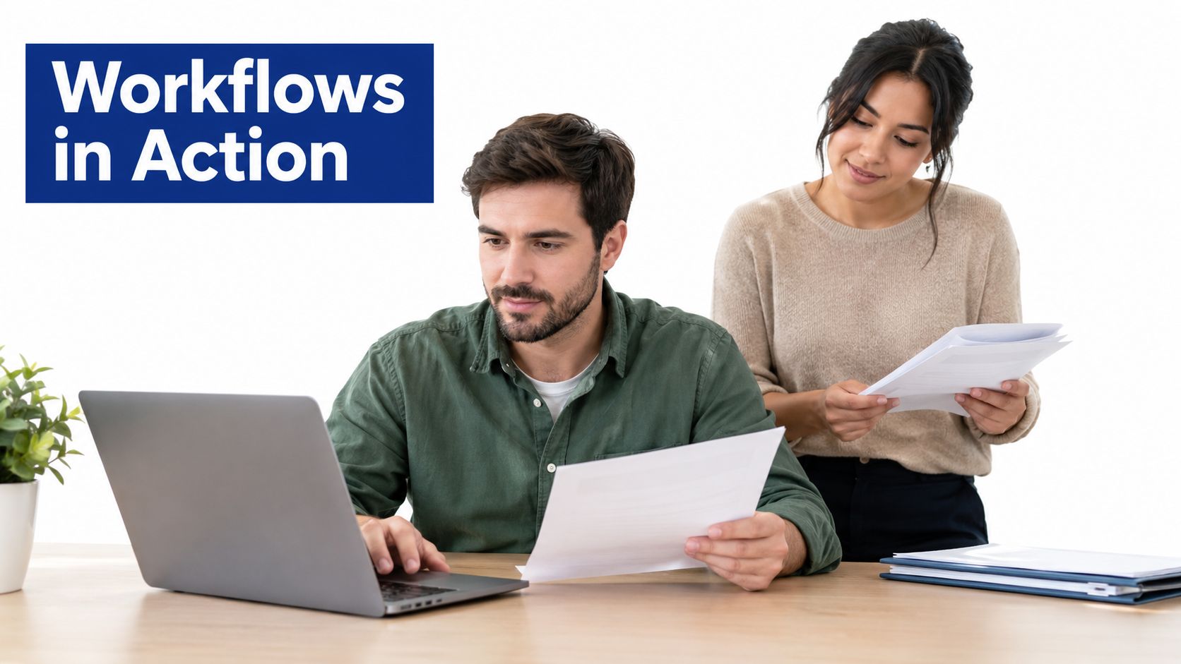 A professional man and woman collaborating on office documents while working together at a laptop computer.